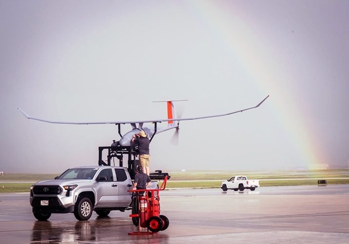 Image of unmanned drone on back of truck and 2 support technicians.